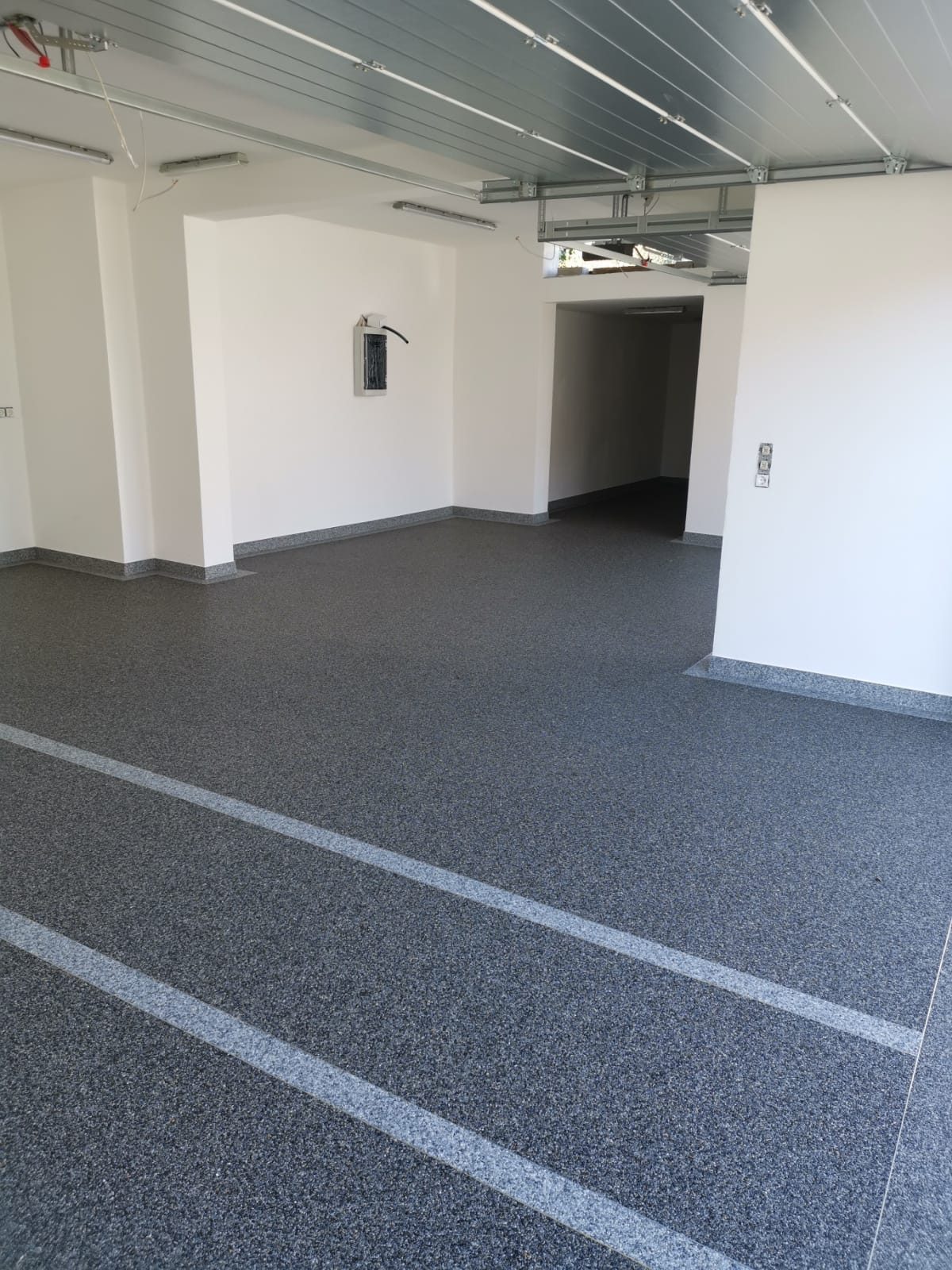 Garagenboden fugenlos beschichtet mit hellen Gestaltungsstreifen